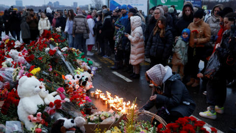 People gather at a makeshift memorial for the victims of Friday's shooting attack outside the Crocus City Hall concert venue near Moscow on March 23, 2024. 
