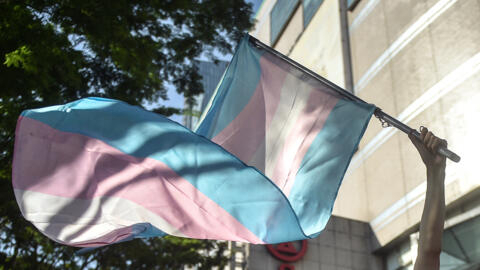 Une femme transgenre brandit un drapeau de la fierté transgenre lors d'une marche au lendemain de la Journée internationale de la femme à Kuala Lumpur, le 9 mars 2024.