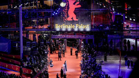 Guests walk on the red carpet past media people to the Berlinale Palast for the opening of the International Film Festival, Berlinale,in Berlin, Thursday, Feb. 15, 2024. (AP Photo/Markus Schreiber)