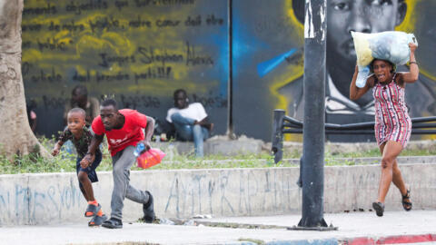 People take cover from gunfire near the National Palace in Port-au-Prince, Haiti, on March 21, 2024.