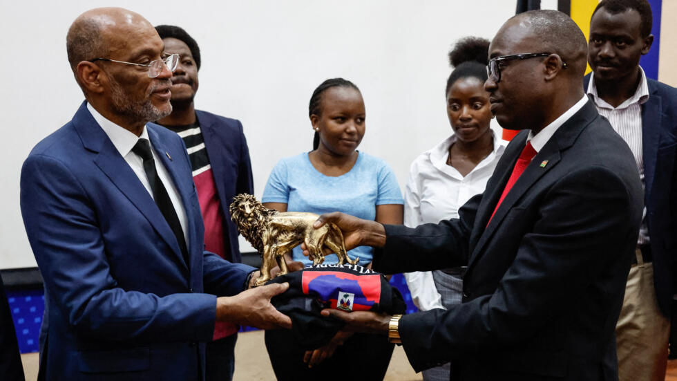 Haitian Prime Minister Ariel Henry receives a gift from the Principal Secretary, State department for foreign affairs Dr. Abraham Korir Sing'Oei at a university in Nairobi on March 1, 2024.