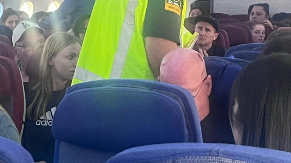 A paramedic walks onboard as passengers look on, after an incident on a LATAM Airlines Boeing 787, in Auckland, New Zealand, March 11, 2024 in this picture obtained from social media.