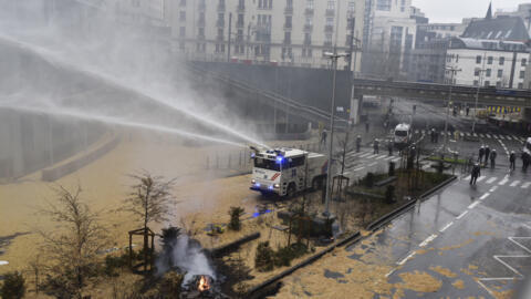 Police spray a water canon during a farmers demonstration in the European Quarter outside a meeting of EU agriculture ministers in Brussels, Monday, Feb. 26, 2024.