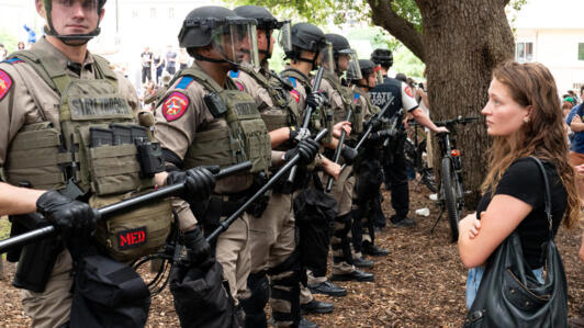 طالب يحدق بهدوء في صف من قوات ولاية تكساس بينما يحتج الطلاب المؤيدون للفلسطينيين على الحرب بين إسرائيل وحماس في حرم جامعة تكساس في أوستن، تكساس، في 24 أبريل 2024.