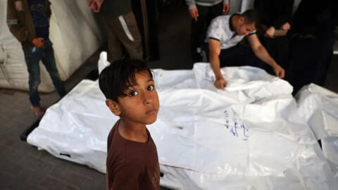 طفل فلسطيني قرب جثامين أفراد عائلته في باحة مشفى النجار في رفح.