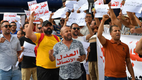 متظاهرون يرفعون لافتات خلال اعتصام لموظفي وأصحاب المخابز أمام مقر وزارة التجارة في تونس العاصمة في 7 آب/أغسطس 2023