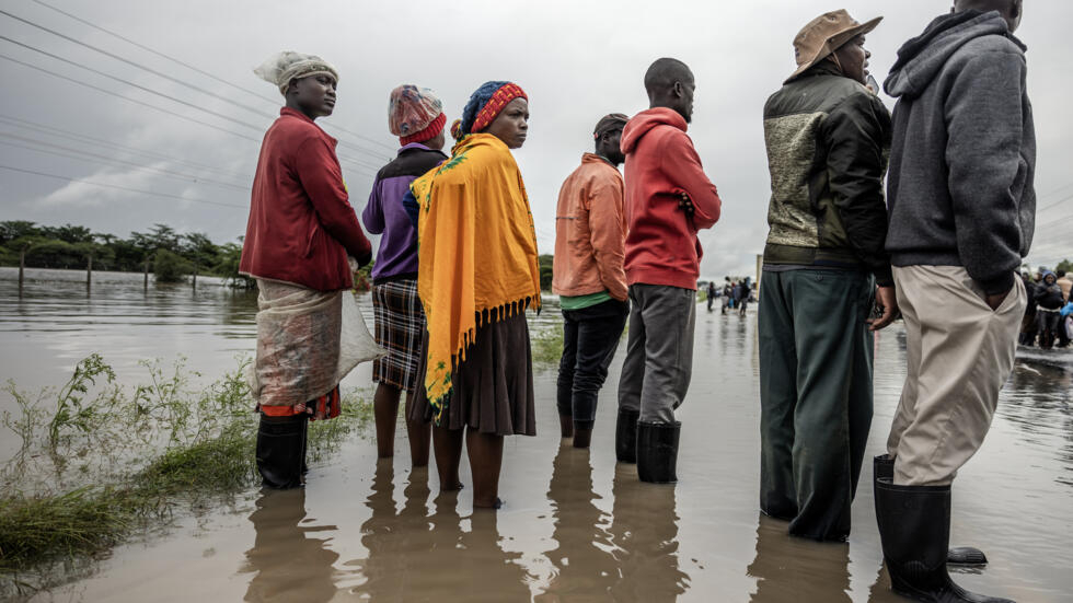 سكان محليون يتفقدون طريقًا متضررًا بشدة جراء فيضانات تسببت بها أمطار غزيرة في بلدة كيتينغيلا في كينيا في الأول من أيار/مايو 2024