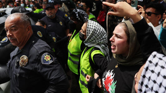 متظاهرون مؤيدون لفلسطين يصرخون تجاه ضباط السلامة العامة في جامعة جنوب كاليفورنيا بعد أن حاول الضباط هدم مخيم لدعم غزة في جامعة جنوب كاليفورنيا في 24 أبريل 2024 في لوس أنجلوس، كاليفورنيا.