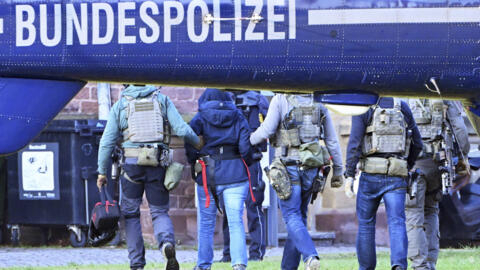 Иллюстративное фото: в Германии задержанных ведут к полицейскому вертолету.