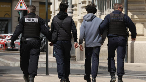 Police officers detain two teenagers in Beziers, southern France, on April 23, 2024. The mayor of Beziers Robert Menard has introduced a curfew for minors under the age of 13 in several districts, he said on April 23, 2024, the day on which unions and left-wing associations will be demonstrating against far-right ideas in the town. (Photo by Pascal GUYOT / AFP)