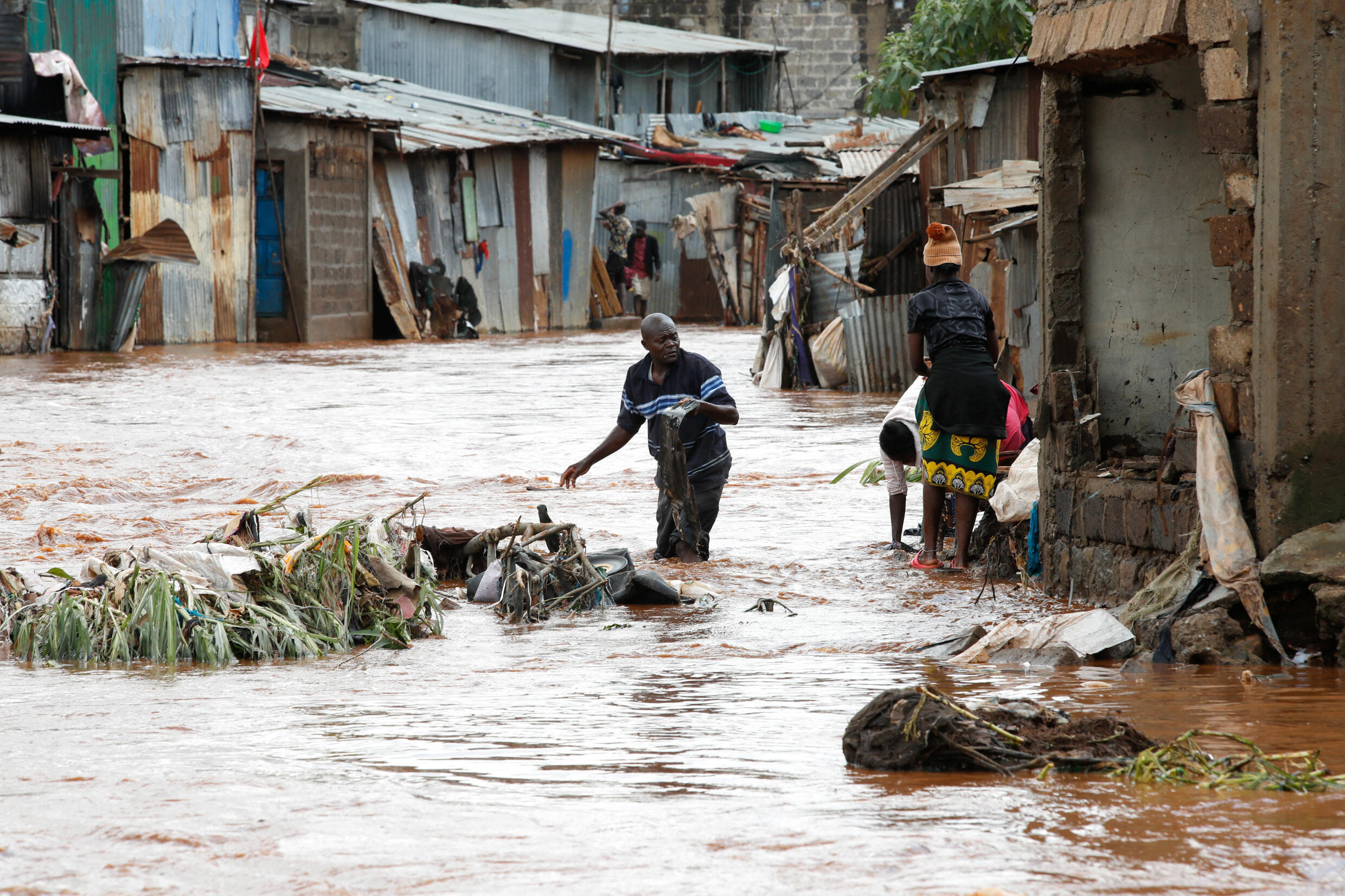Residents wade through flood waters as they try to recover their belongings after the Nairobi river burst its banks within the Mathare valley settlement in Nairobi.