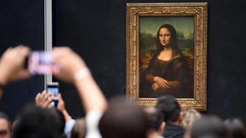 Visitors take pictures in frront of Mona Lisa at the Louvre museum in Paris.