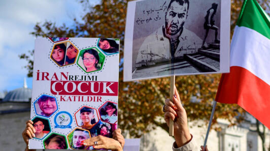Des manifestants tiennent des pancartes où figurent des portraits du rappeur iranien Toomaj Salehi (à droite), qui a été arrêté en Iran, et des portraits d'enfants (à gauche), qui ont été tués lors des manifestations dans le pays, lors d'un rassemblement à Istanbul, en novembre 2022 (photo d'illustration).