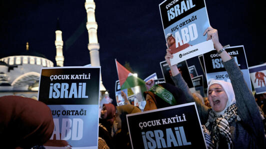 Demonstrators hold placards reading  as they attend a rally in support of Palestinians, outside the Israeli Consulate, in Istanbul on October 18, 2023.