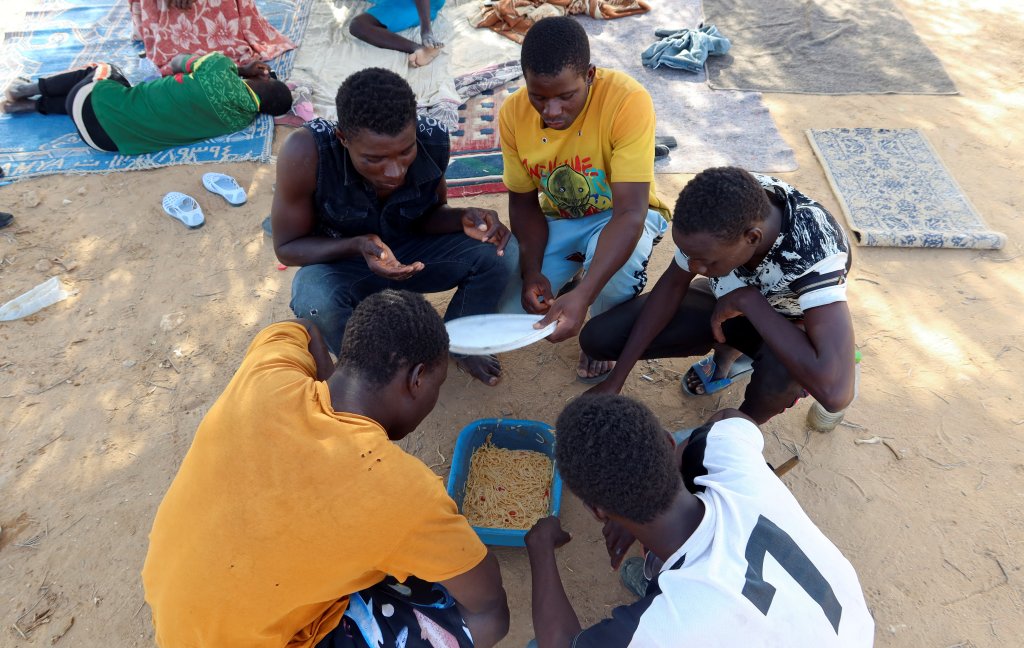 Des migrants mangent un repas, près de Sfax, à Jebiniana, en Tunisie, le 4 septembre 2023. Crédit : Reuters