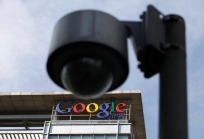 The Google logo is seen on the top of its China headquarters building, behind a road surveillance camera in Beijing