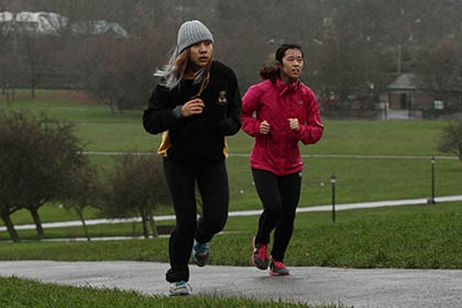 Two joggers run through a park