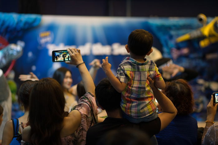 Father holding his son on showder to see the show