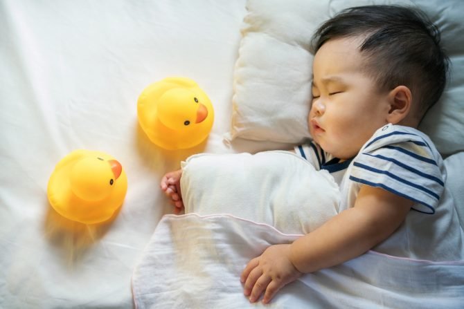 Newborn baby sleep with duck on ther bed