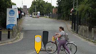 A woman passes the entrance of the Thames Water plant in Twickenham, London, Wednesday, June 28, 2023.(AP Photo/Frank Augstein)