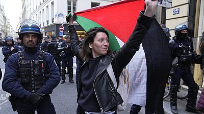 A woman holds a Palestine flag near Sciences-Po university in Paris