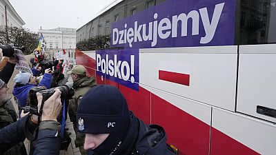 People cheer as a bus carrying Polish Prime Minister Donald Tusk and his ministers leave heading to the presidential palace in Warsaw, Poland (AP Photo/Czarek Sokolowski)