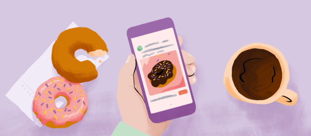 A cup of coffee, two donuts, and a hand holding a phone that shows an ad for a bakery.