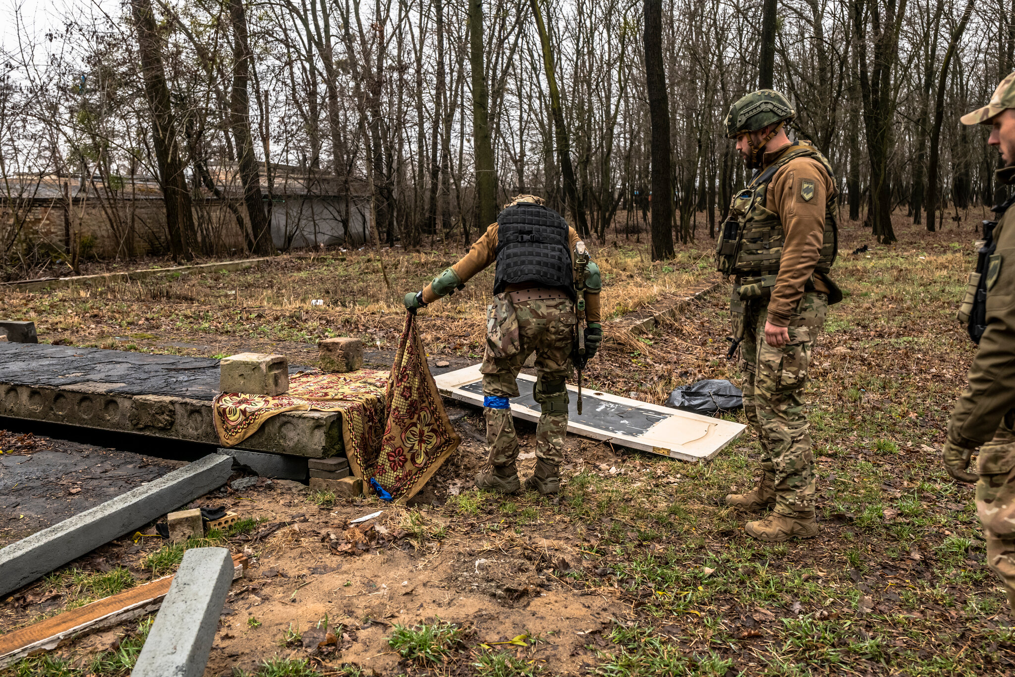 Ukrainian soldiers of the Azov battalion examined an underground space where the bodies of two civilians, a man and a woman, had been dumped.