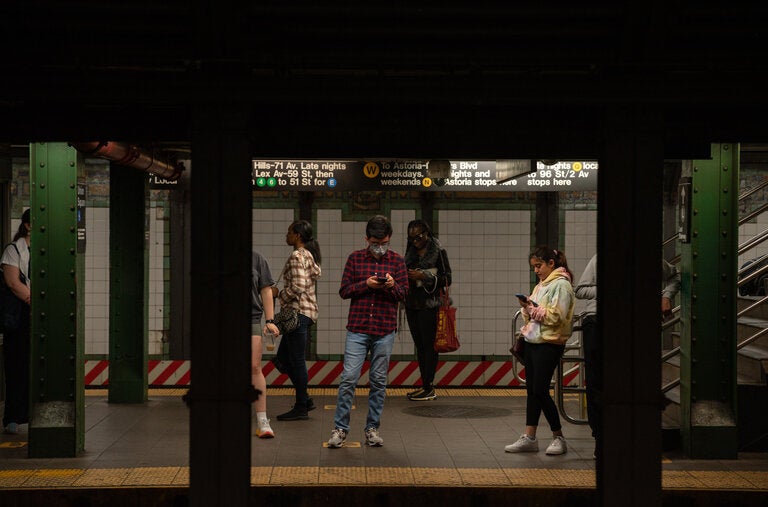 Riders, one wearing a mask, waited for a train at the Union Square station in New York City, as the federal public health emergency expired on Thursday.
