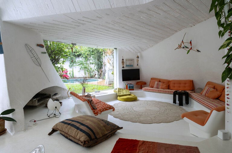 The sunken living room of the family beach house, with its sculptural concrete ceiling.