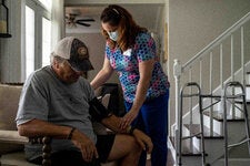 April Abel, a former home health nurse at Roper St. Francis Healthcare, in the home of a patient, Ron Keur, in Summerville, S.C., in 2022.