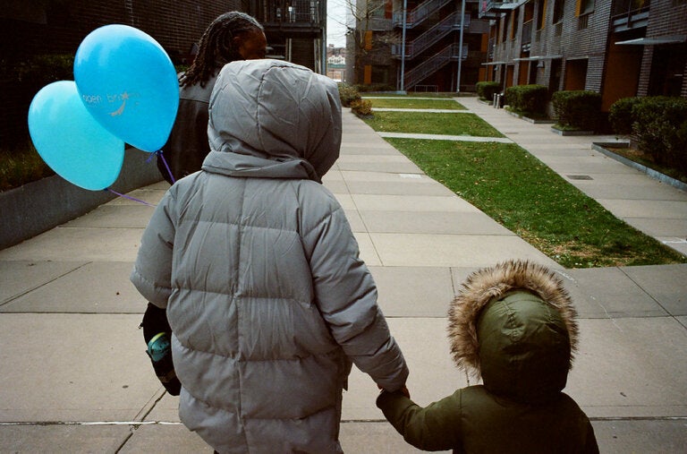 Akilah Browne and her son walk with their neighbor Eduardo González. They were early buyers of Via Verde’s co-op apartments.