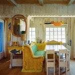 Carousel-inspired banquettes and a dining table in the main room of the cabanon, a retrofitted 1960s fisherman’s cottage.