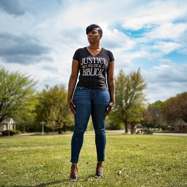 Crystal Mason stands in a grassy field wearing a T-shirt that says, “Justice isn’t political, it’s biblical.”