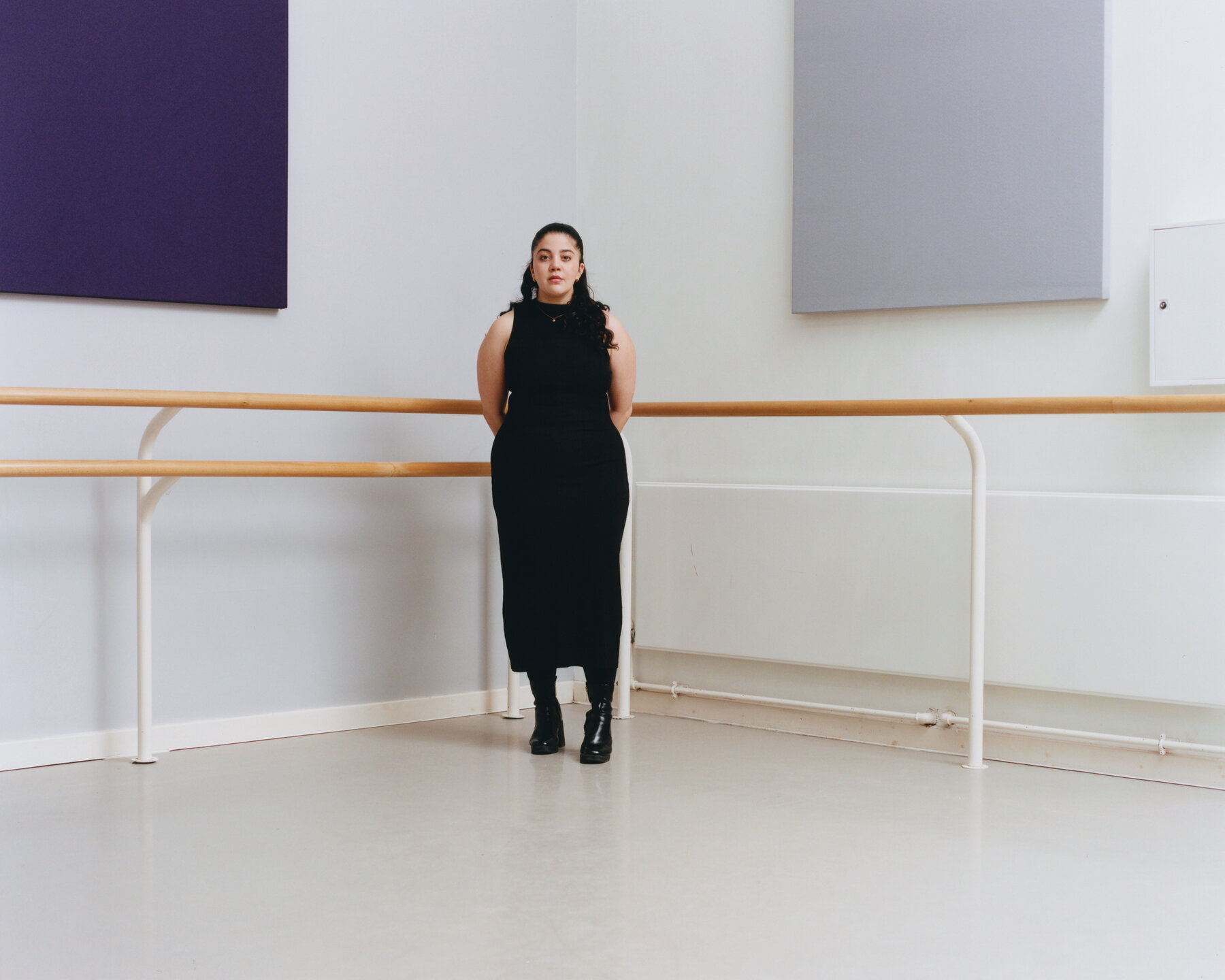 Arielle Smith stands with her hands behind her back in the corner of a dance studio.