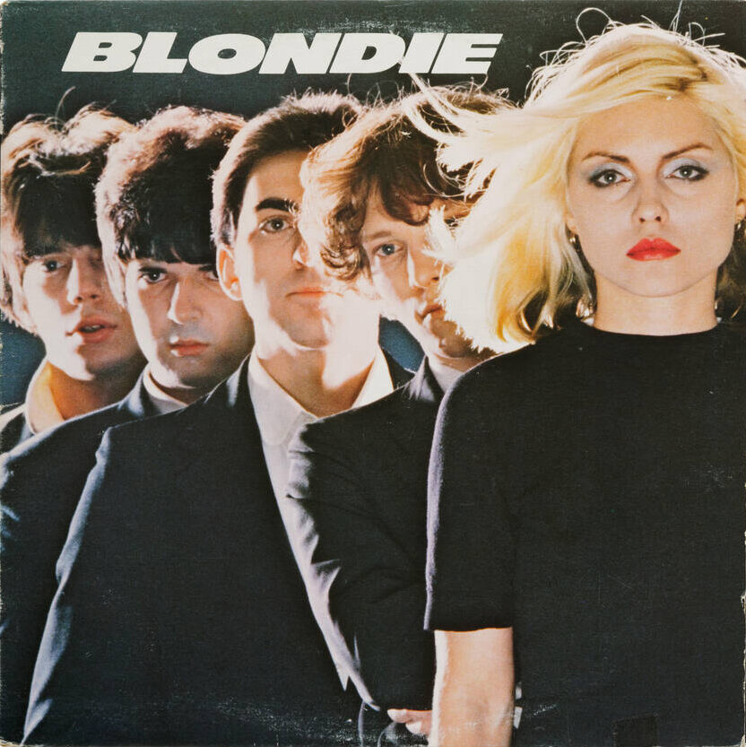 The cover of the album Blondie, with the title in capital letters and italicized. It shows five people dressed in black tops and jackets standing in front of each other.