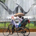A rickshaw passing by a water fountain during an ongoing heat wave in Dhaka, Bangladesh, on Saturday.