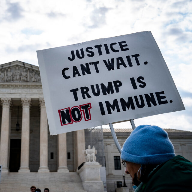 A demonstrator outside the Supreme Court holding up a sign that reads “Justice can’t wait. Trump is not immune.”
