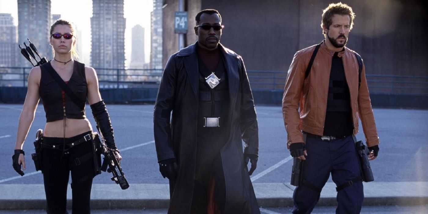 Wesley Snipes, Jessica Biel, and Ryan Reynolds walk with loaded weapons on a street in Blade: Trinity