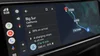 YouTube Video showing: EV routing information for a trip to Big Sur, a Google Assistant on-screen command to open a garage door, a smart reply for an incoming text message, and a voice command asking the Google Assistant to play a road trip playlist.