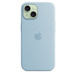 iPhone 15:n vaaleansininen MagSafe-silikonikuori, upotettu Apple-logo keskellä, kiinnitetty vihreään iPhone 15:een, joka näkyy kameralle tehdystä aukosta.