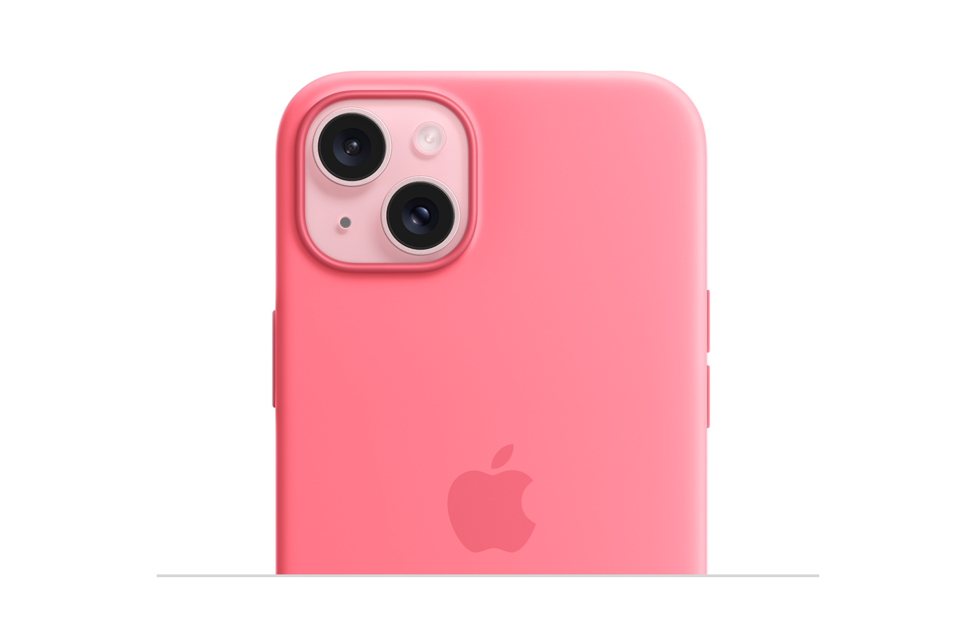 เคสซิลิโคนสำหรับ พร้อม MagSafe สีชมพูที่มีโลโก้ Apple ฝังอยู่ตรงกลาง และติดเข้ากับ iPhone 15 สีชมพูที่มองเห็นผ่านช่องที่เจาะไว้สำหรับกล้อง
