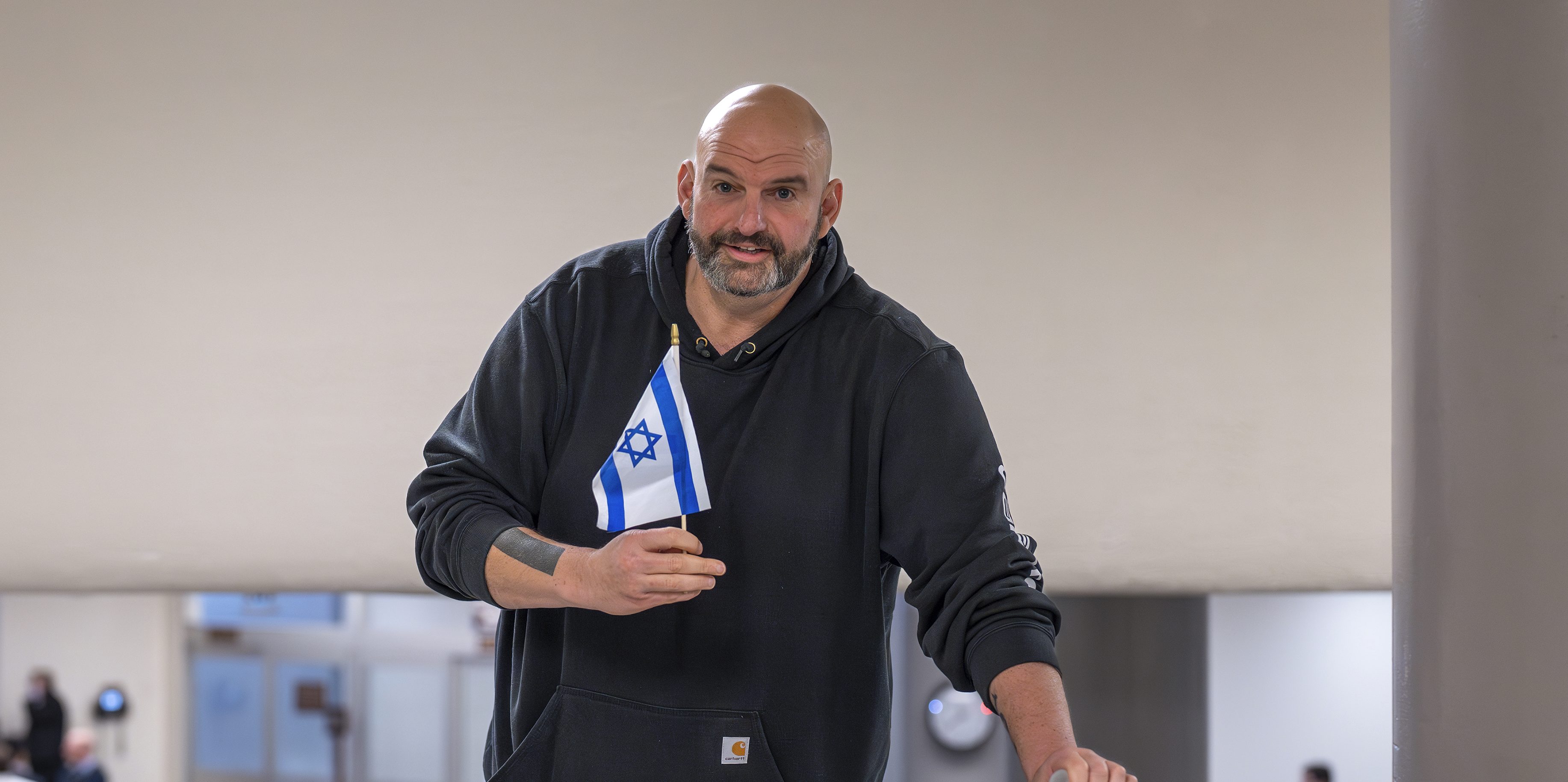 Sen. John Fetterman, D-Pa., holds a small Israel flag as he heads to the chamber for a vote, at the Capitol in Washington, Thursday, Jan. 25, 2024. (AP Photo/J. Scott Applewhite)