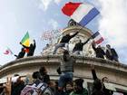 People holding a poster and waving flags take part in a solidarity march in the streets of Paris