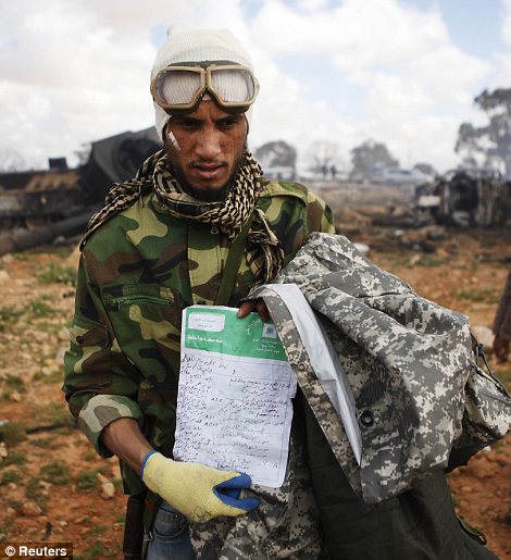 Meanwhile a rebel fighter shows official government documents found at the scene of an attack