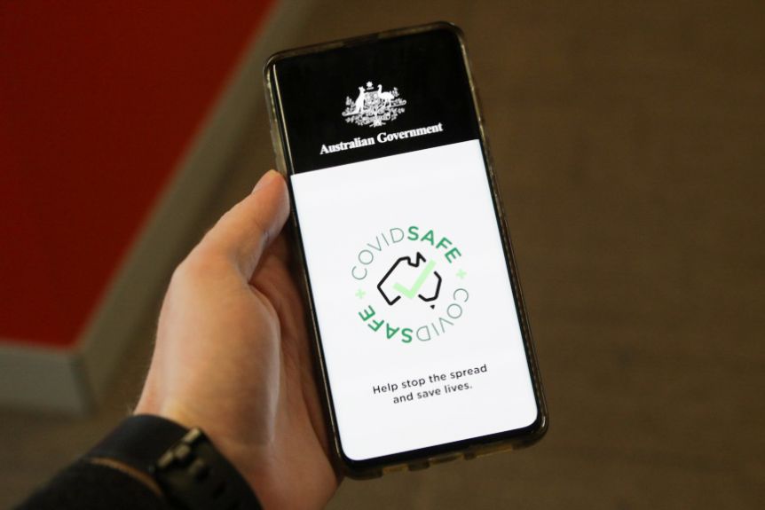 A mobile phone held in a person's left hand shows the homepage of a government health app.