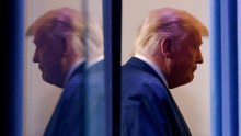 US President Donald Trump reflected in glass wearing a suit