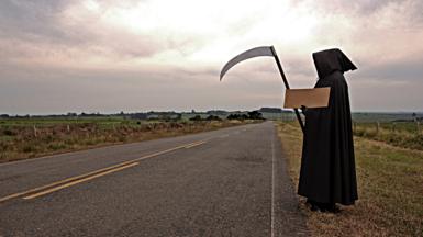 Grim reaper hitch-hiking by the roadside