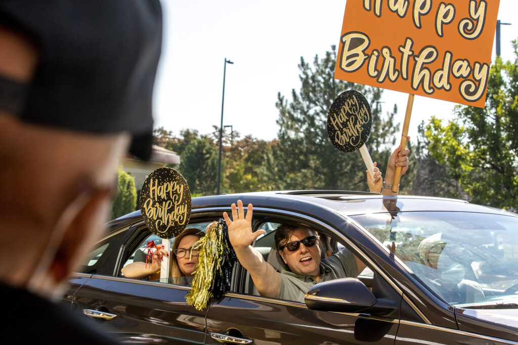 People celebrating birthday with posters and banners in a car