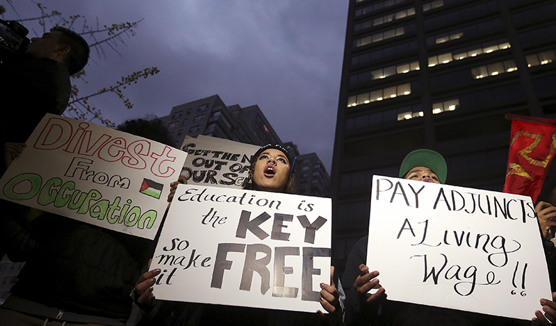 Students hold up signs and chant slogans as they attend a demonstration calling for lower tuition at Hunter College in the Manhattan borough of New York November 12, 2015. Students held rallies on college campuses across the United States on Thursday to protest ballooning student loan debt for higher education and rally for tuition-free public colleges and a minimum wage hike for campus workers. REUTERS/Carlo Allegri